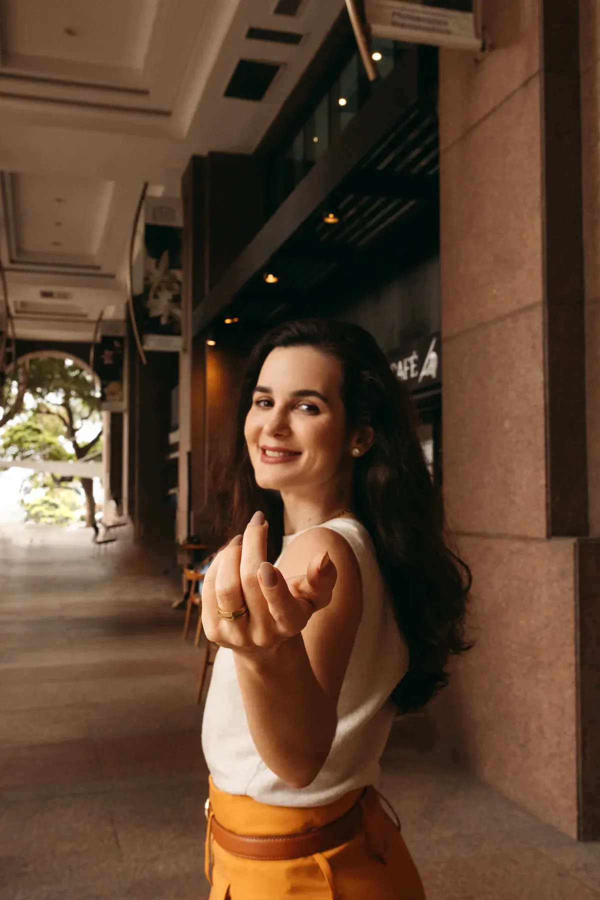 Jéssica Ribeiro estendendo a mão em ambiente externo